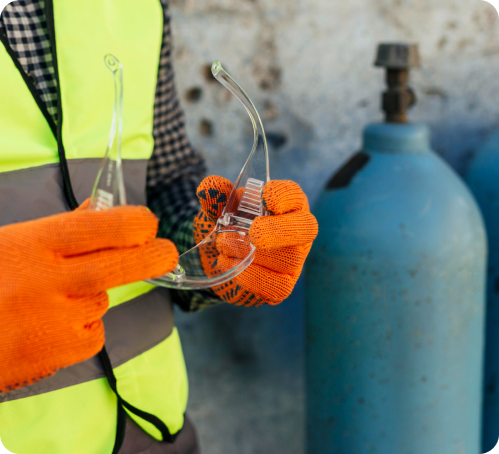 A hand holding safety goggles