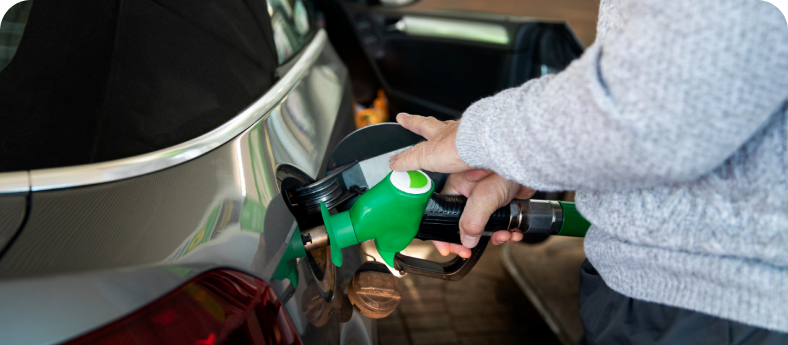 A hand pumping gas into a car